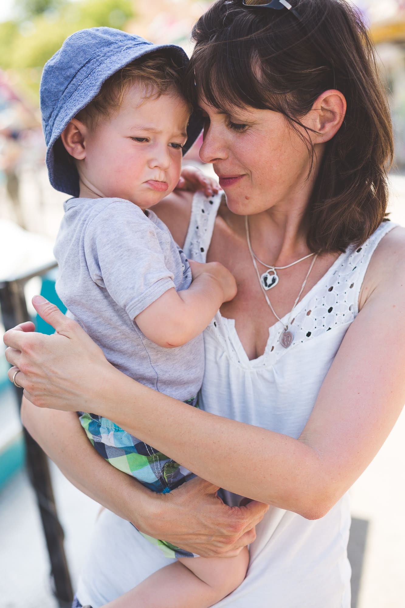 Kleiner Junge auf Mamas Arm ist traurig