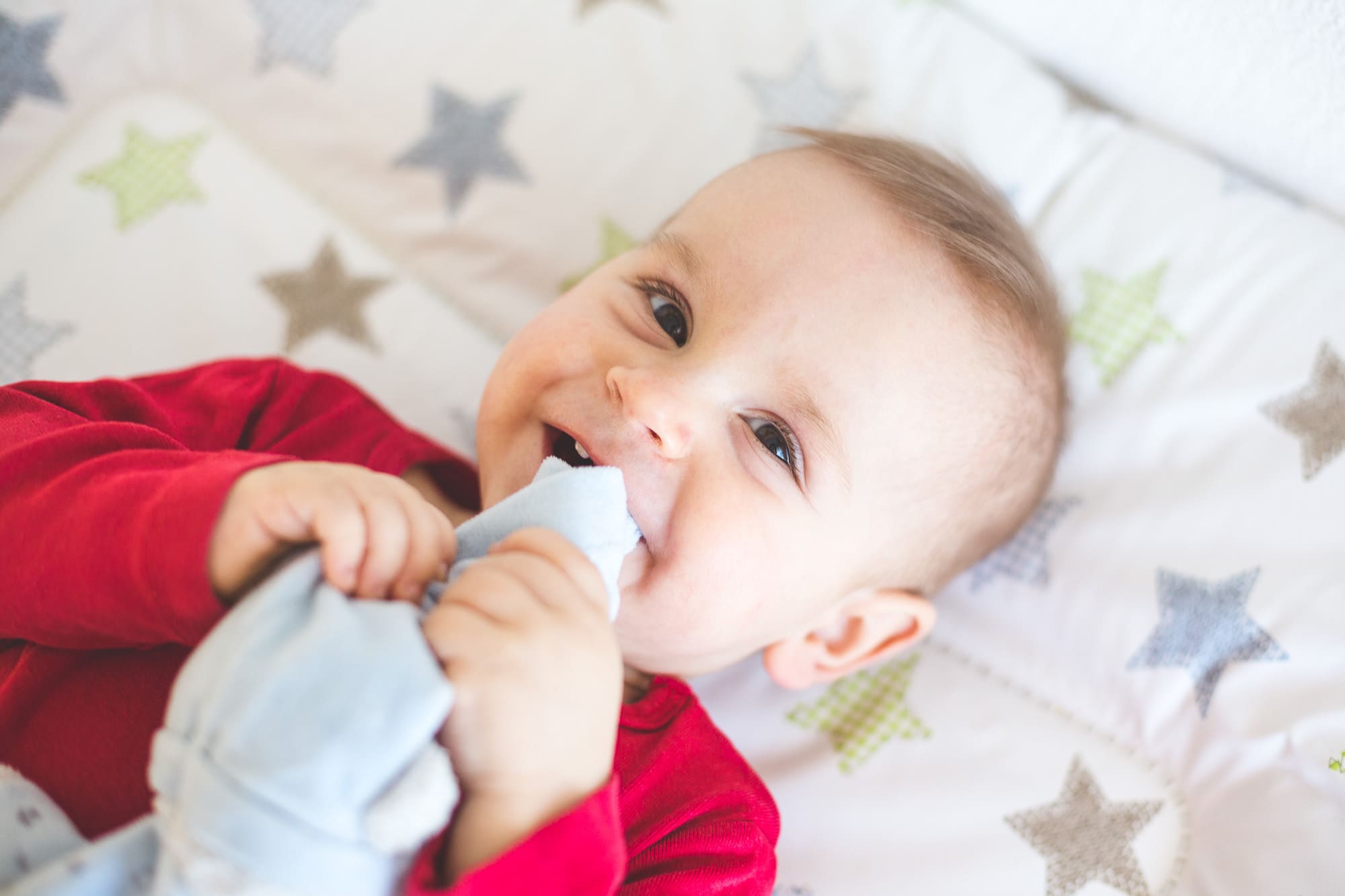 Kleiner Junge auf Wickeltisch lacht in die Kamera