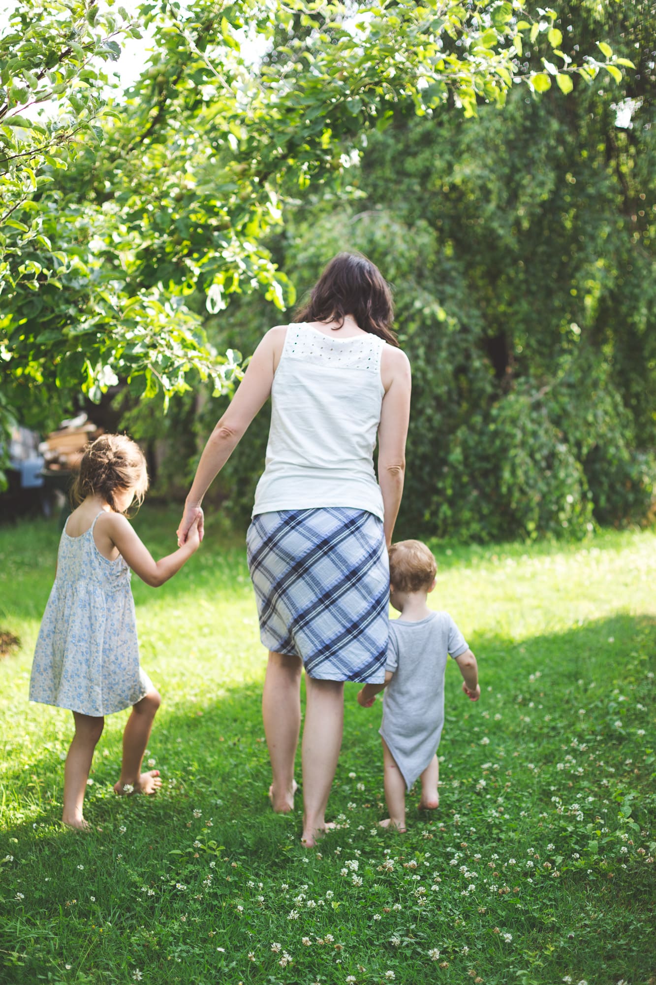 Mama mit Tochter und Sohn Hand in Hand im Garten